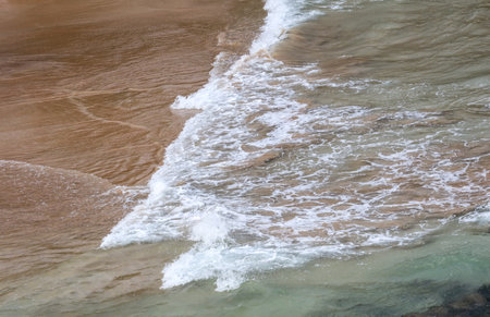 The ocean is a beautiful shade of blue and green. The water is calm and the waves are smallの写真素材