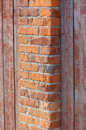 A brick wall with a wooden frame. The wall is made of red bricksの写真素材