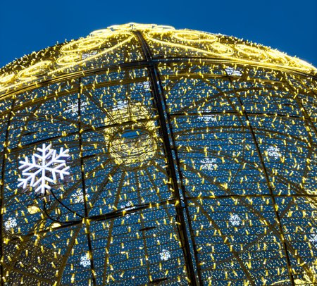 A large, illuminated Christmas tree with snowflakes on it. The snowflakes are lit up and are visible from the top of the treeの写真素材