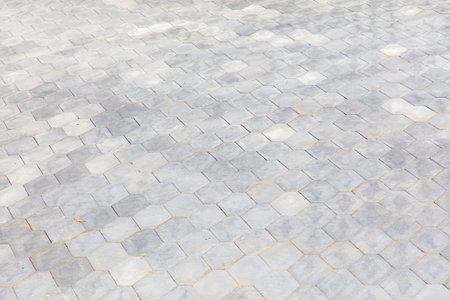 Gray tile floor with a pattern of squares. The tiles are gray and white. The floor is made of bricks