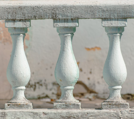 Three white pillars with green paint on them. The pillars are in a rowの写真素材