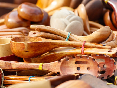 Pile of wooden spoons and a wooden ladle. The spoons are tied together with rubber bandsの写真素材