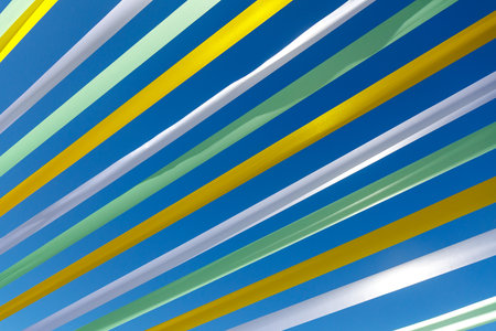 A blue sky with yellow and green stripes. The stripes are in different colors and are very thinの写真素材