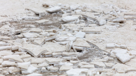 A pile of ice and snow with many pieces of ice. The ice is scattered all over the ground