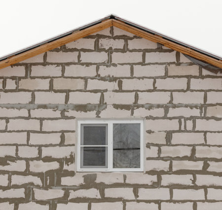 A window is on the side of a building. The window is white and has a clear glass paneの写真素材