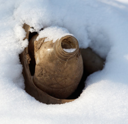 A bottle is in the snow. The bottle is emptyの写真素材