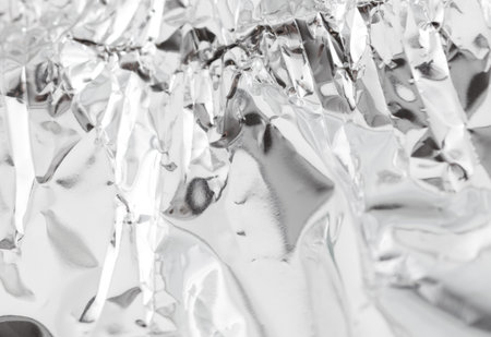 A piece of foil is crumpled and has a shiny surface. It is silver in color