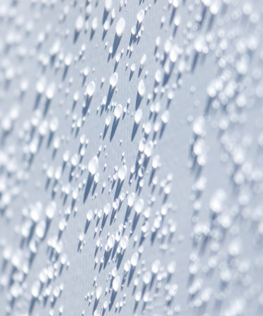A close up of a wet surface with many small droplets of water. The droplets are scattered all over the surfaceの写真素材