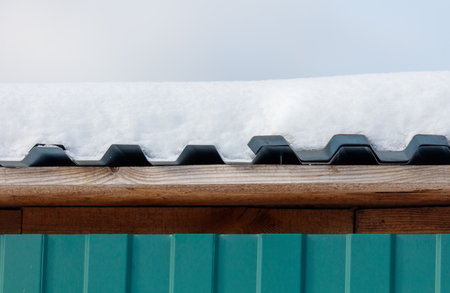 A roof covered in snow. The roof is woodenの写真素材