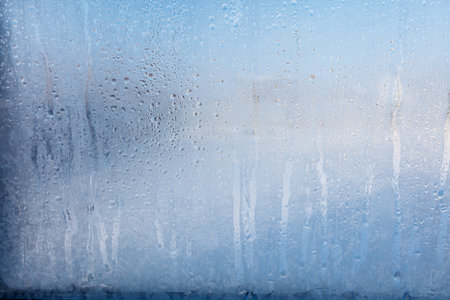 Frozen water drops on glass as an abstract background. Texture.