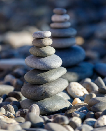 A stack of rocks is on the ground. There are three rocks in the stack. The rocks are gray and blackの写真素材