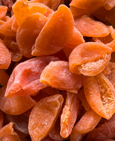 A pile of dried fruit with a few pieces missing. The fruit is orange and dried.