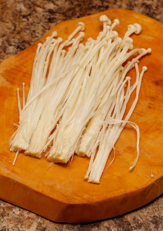 Fried Enoki mushrooms on a wooden board.