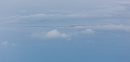 A blue sky with clouds. The clouds are white and scattered. The sky is clear and bright