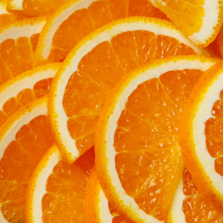 A close up of orange slices. The slices are cut in half and are arranged in a circleの写真素材