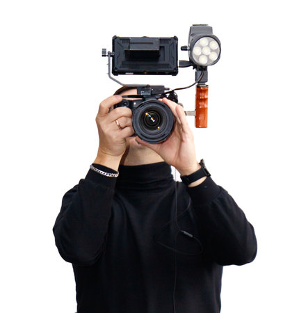 A man is holding a camera with a lens on his face.の写真素材