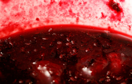 A bowl of red liquid with a red rim. The liquid is thick and has a dark colorの写真素材
