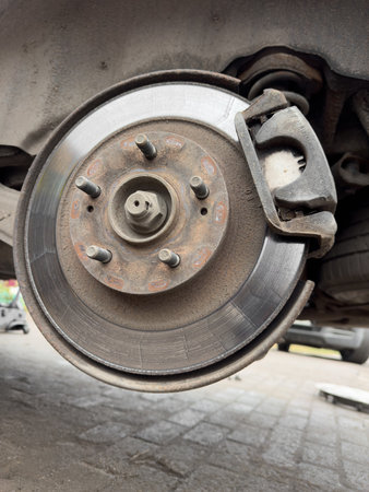 A wheel is shown with a brake pad on it. The brake pad is worn and the wheel is dirtyの写真素材