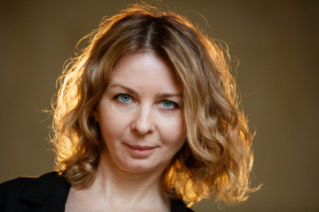 A woman with brown hair and blue eyes. She is wearing a black shirt. She is smilingの写真素材