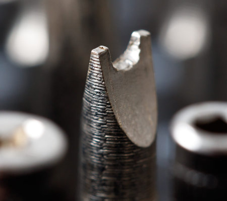 A silver object with a pointed end. It is a screwdriver bit