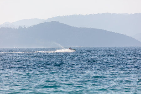 A jet ski is in the water with a person on it. The jet ski is leaving a wakeの写真素材