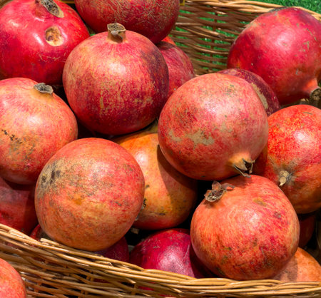 A basket full of red pomegranates. The pomegranates are ripe and ready to eat