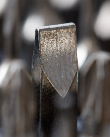 A close up of a screwdriver with a pointed tip. There are several other screwdrivers in the...