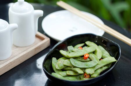 green beans with red chilli in black ceramic bowlの写真素材