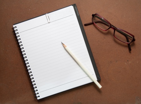 new black notebook with white pencil, paper clip and glassesの写真素材