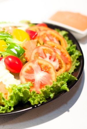 serving of healthy vegetables salad with dressing on the sideの写真素材