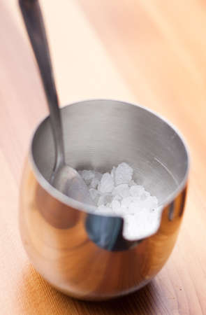 stainless steel bowl of sugar on wood backgroundの写真素材
