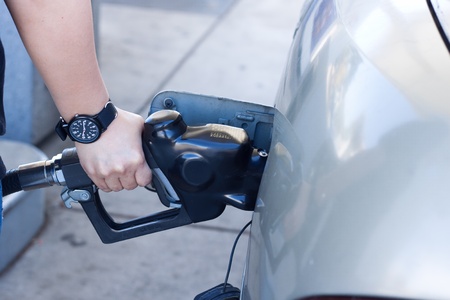 close up of woman hand putting gas into the car at gas stationの写真素材