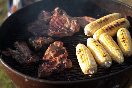 Grilling steaks and corns on BBQの写真素材