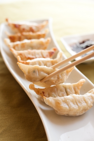Gyoza and chopsticks on white plateの写真素材