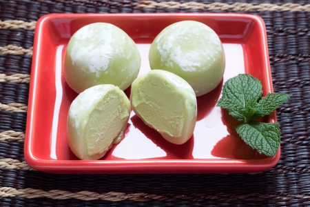 Green tea mochi ice cream on red plateの写真素材