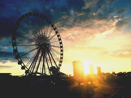 Ferris wheel under beautiful sunset skyの素材