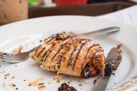 Chocolate croissant after eaten on white plateの写真素材