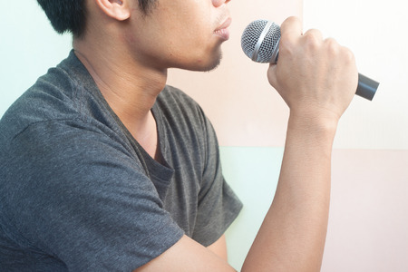 Close up of man singing into microphoneの写真素材