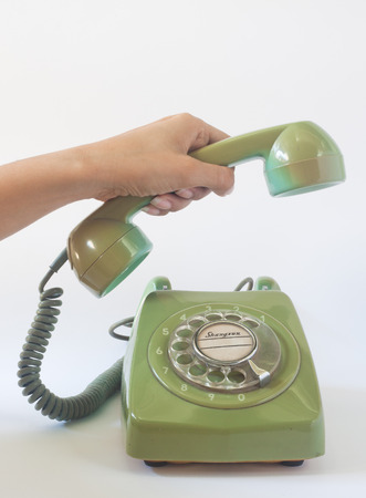 Woman holding on the old telephone on white backgroundの写真素材