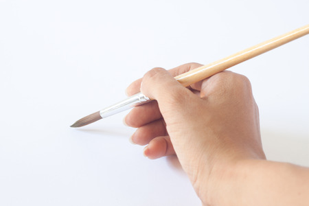 Hand with a brush. Over a grey empty paper, drawing imitationの写真素材
