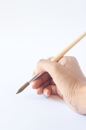 Hand with a brush. Over a grey empty paper, drawing imitationの写真素材