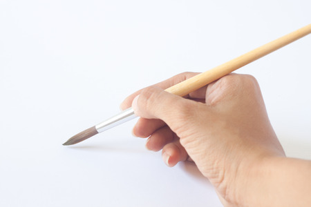 Hand with a brush. Over a grey empty paper, drawing imitationの写真素材
