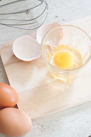 ingredients and tools to make a cake, eggs, bakery cups on wood tableの写真素材