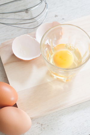 ingredients and tools to make a cake, eggs, bakery cups on wood tableの写真素材