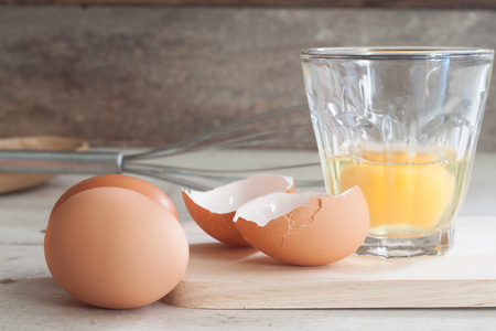 ingredients and tools to make a cake, eggs, bakery cups on wood tableの写真素材
