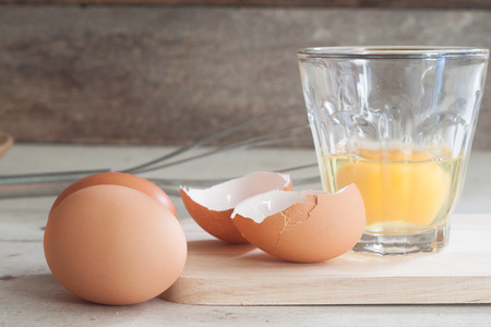 ingredients and tools to make a cake, eggs, bakery cups on wood tableの写真素材