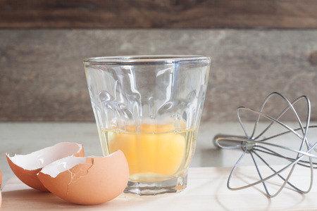 ingredients and tools to make a cake, eggs, bakery cups on wood tableの写真素材