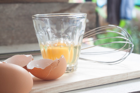 ingredients and tools to make a cake, eggs, bakery cups on wood tableの写真素材
