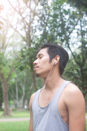 asian man relaxing while listening musicの写真素材