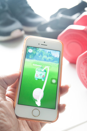 Bangkok, Thailand - August 10, 2016 : Apple iPhone5s held in one hand showing its screen with Pokemon Go application.のeditorial素材